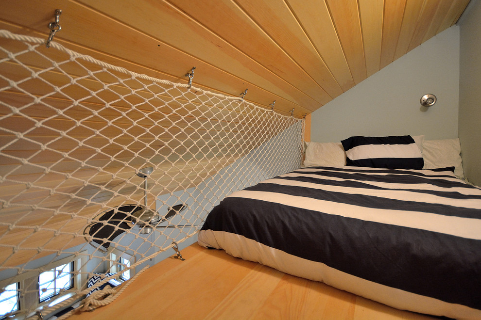 Diseño de dormitorio tipo loft clásico pequeño sin chimenea con suelo de madera clara y paredes grises