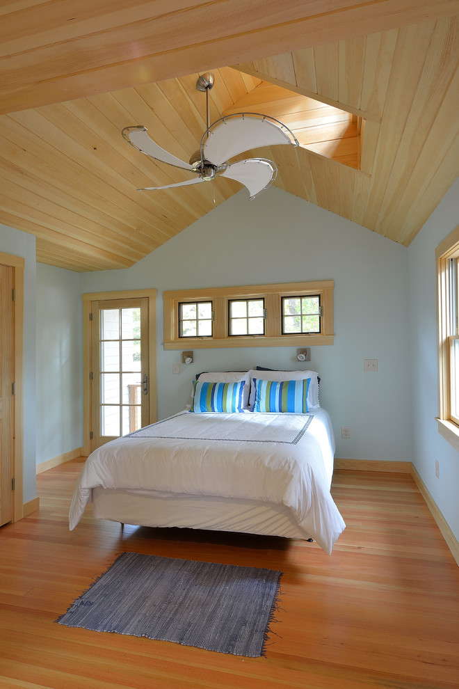 Idées déco pour une chambre parentale éclectique avec un mur bleu et un sol en bois brun.