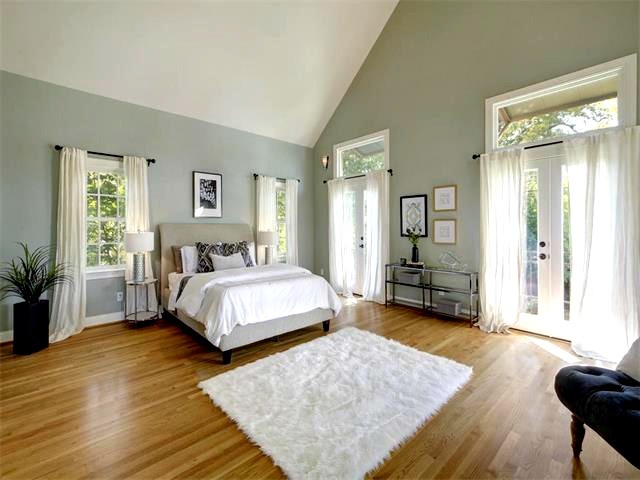Modelo de dormitorio principal tradicional renovado extra grande con paredes grises y suelo de madera en tonos medios