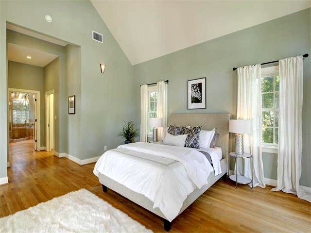Imagen de dormitorio principal clásico renovado grande con paredes grises y suelo de madera en tonos medios