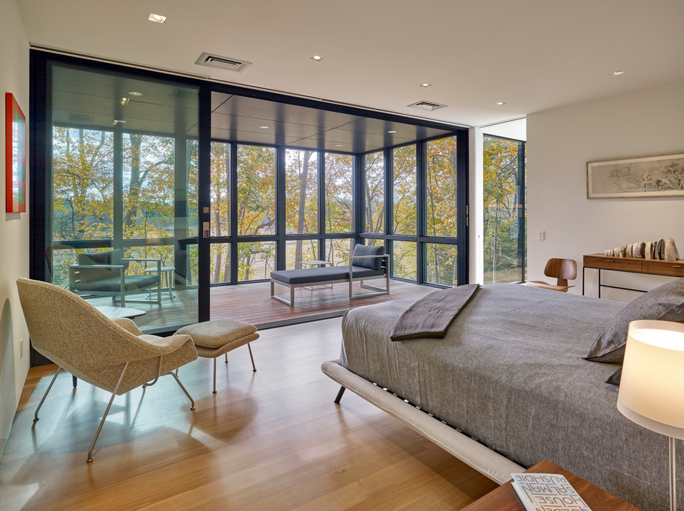 Modernes Schlafzimmer mit weißer Wandfarbe, braunem Holzboden und braunem Boden in Wilmington