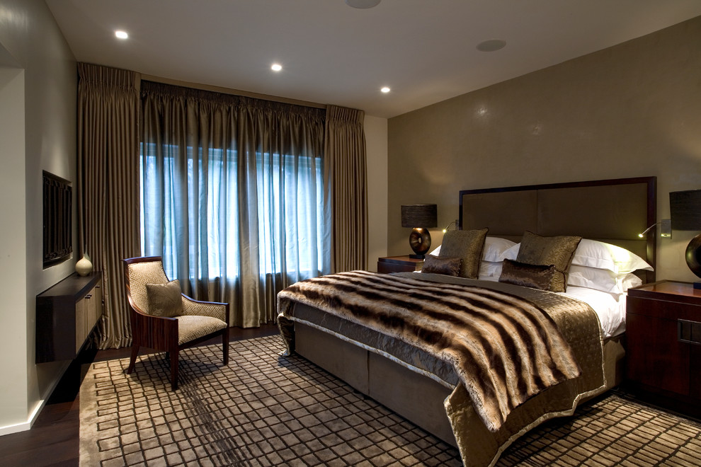 Medium sized contemporary master bedroom in London with dark hardwood flooring, brown floors, brown walls, no fireplace and a feature wall.