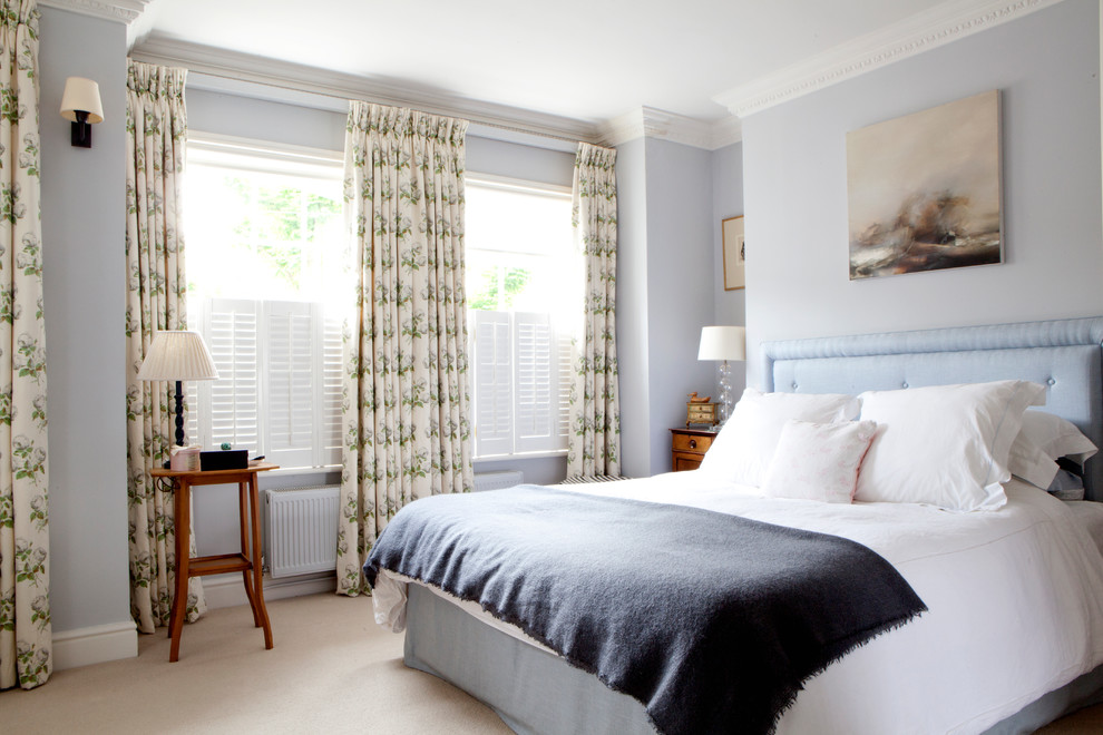 Inspiration for a medium sized traditional master bedroom in London with carpet, blue walls and beige floors.