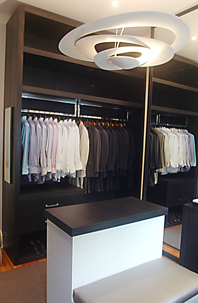 Ejemplo de armario y vestidor moderno de tamaño medio con suelo de madera clara