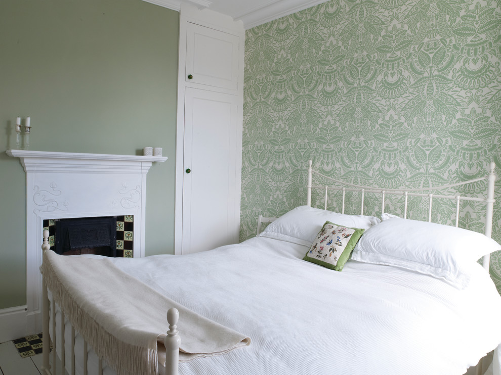На фото: большая хозяйская спальня в современном стиле с зелеными стенами, стандартным камином и фасадом камина из плитки с