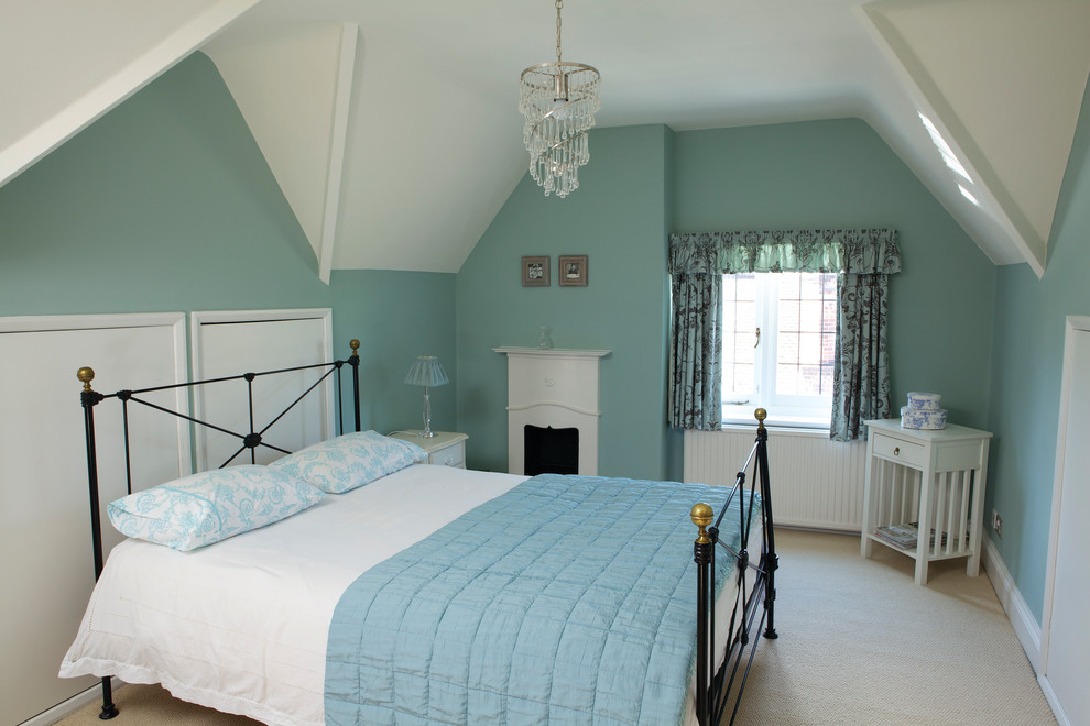 Inspiration för klassiska sovrum, med en spiselkrans i trä, blå väggar och en standard öppen spis