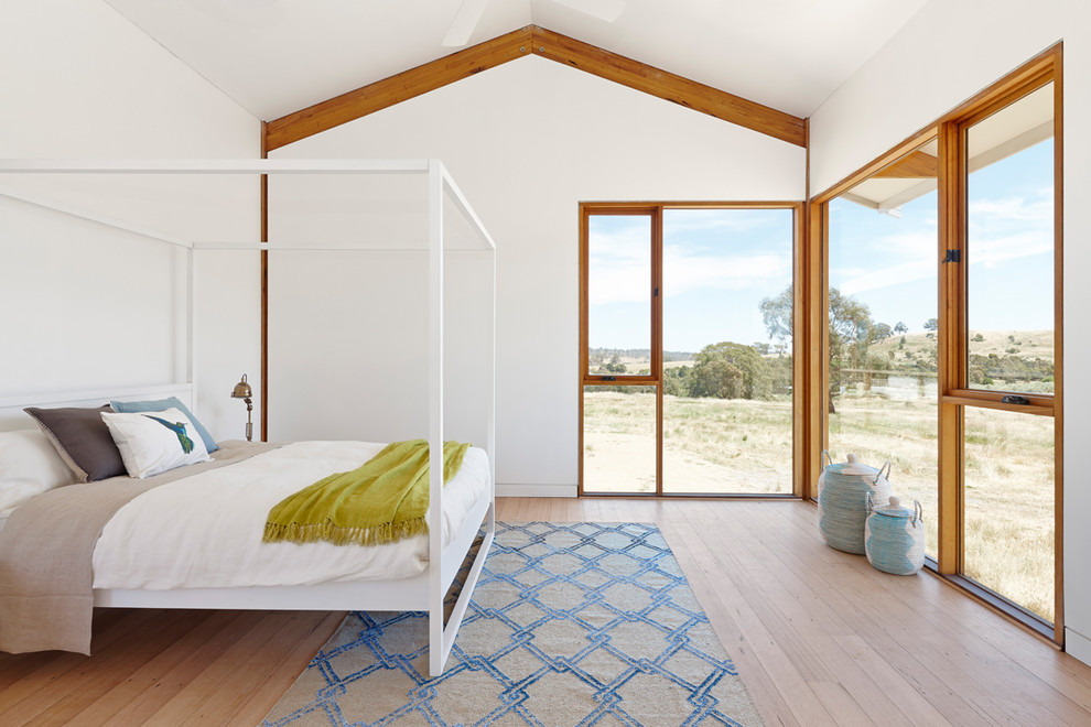 Ejemplo de dormitorio principal clásico renovado con paredes blancas, suelo de madera clara y suelo beige