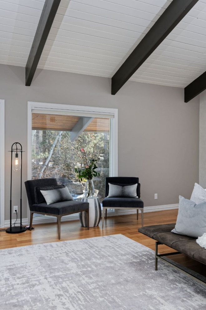 Exemple d'une chambre parentale tendance de taille moyenne avec un mur beige, un sol en bois brun et aucune cheminée.