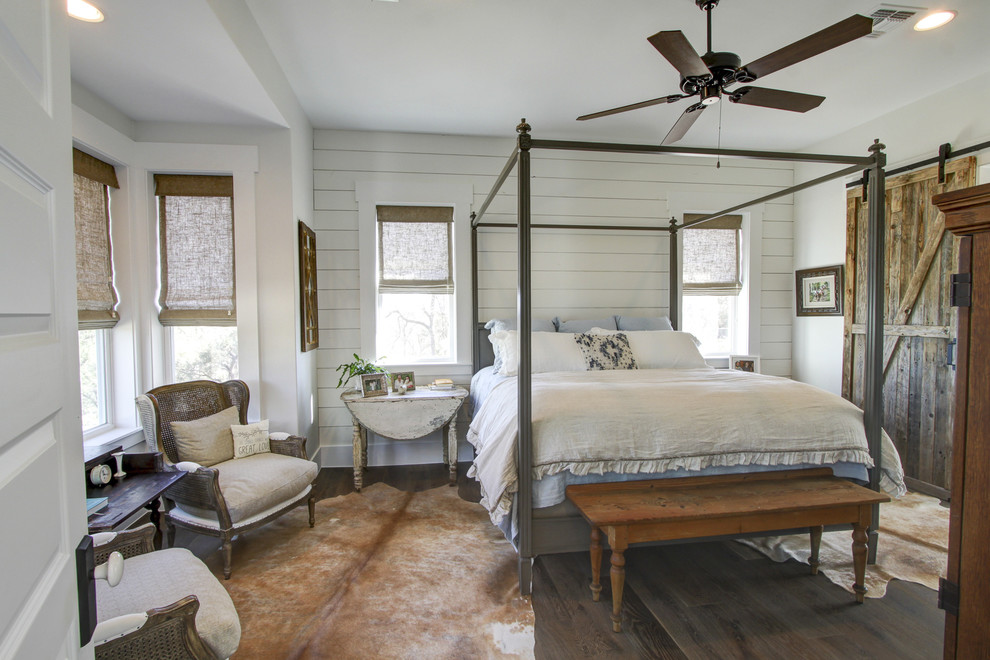 Mittelgroßes Country Hauptschlafzimmer ohne Kamin mit weißer Wandfarbe, braunem Boden und dunklem Holzboden in Austin