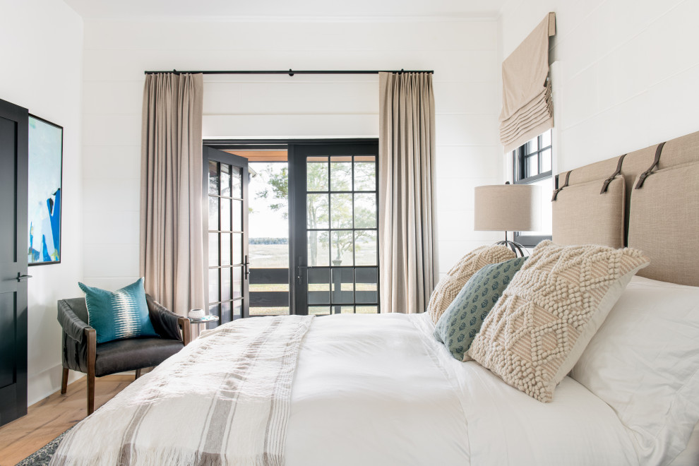 Modelo de habitación de invitados campestre de tamaño medio con paredes blancas, suelo de madera clara y suelo beige