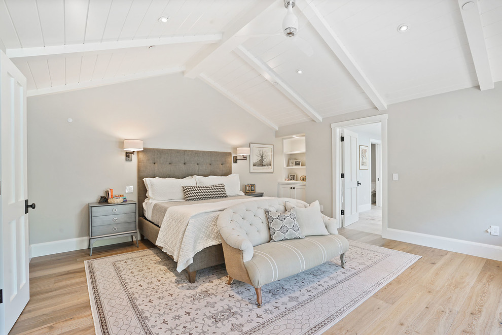 Diseño de dormitorio principal de estilo de casa de campo grande con paredes grises y suelo de madera clara
