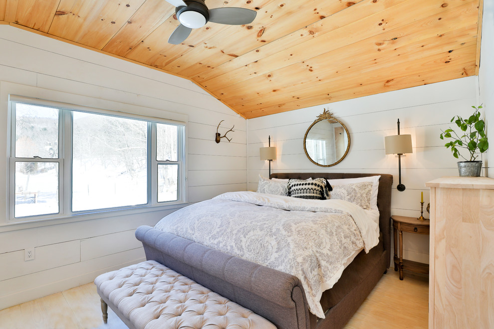 Idee per una camera degli ospiti country con pareti bianche, pavimento in legno massello medio e pavimento beige