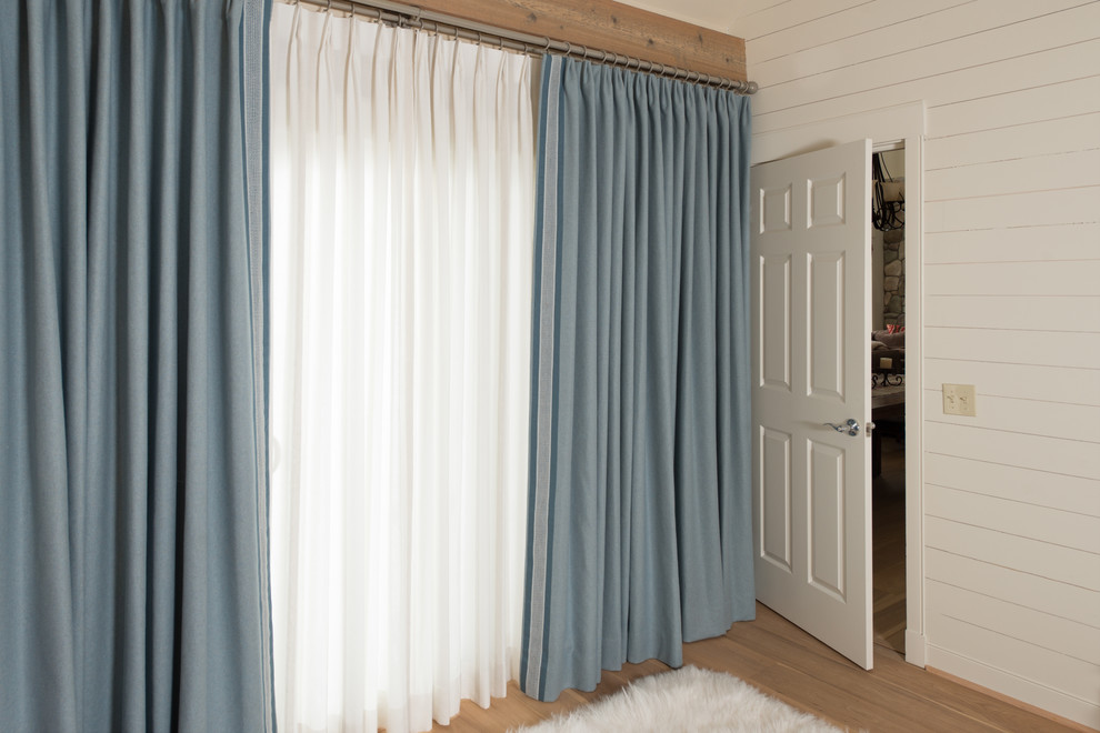 Ejemplo de dormitorio principal campestre de tamaño medio con paredes blancas, suelo de madera clara y suelo beige