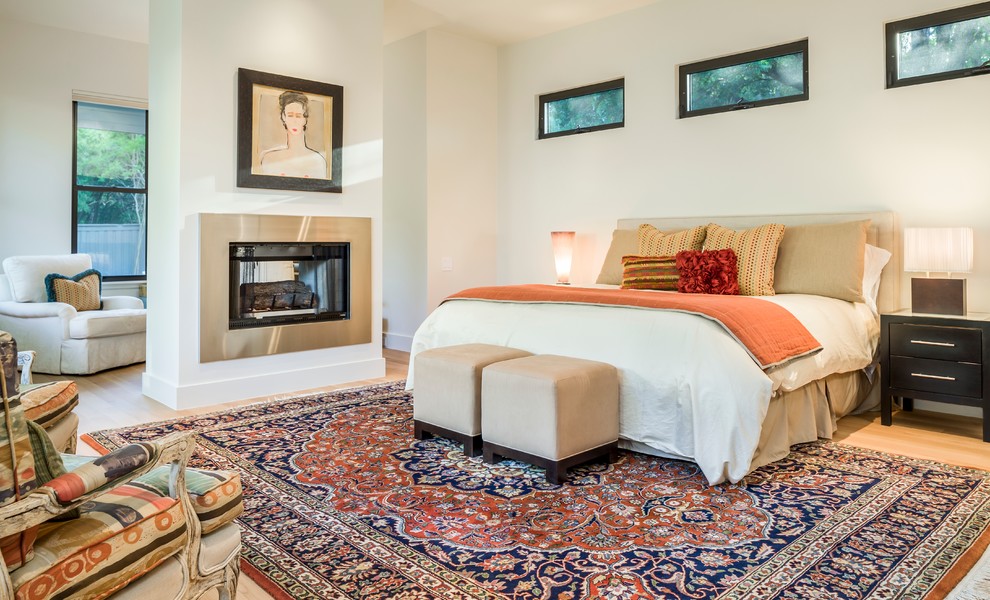 Country Hauptschlafzimmer mit grauer Wandfarbe, hellem Holzboden, Kaminumrandung aus Metall und Tunnelkamin in Dallas