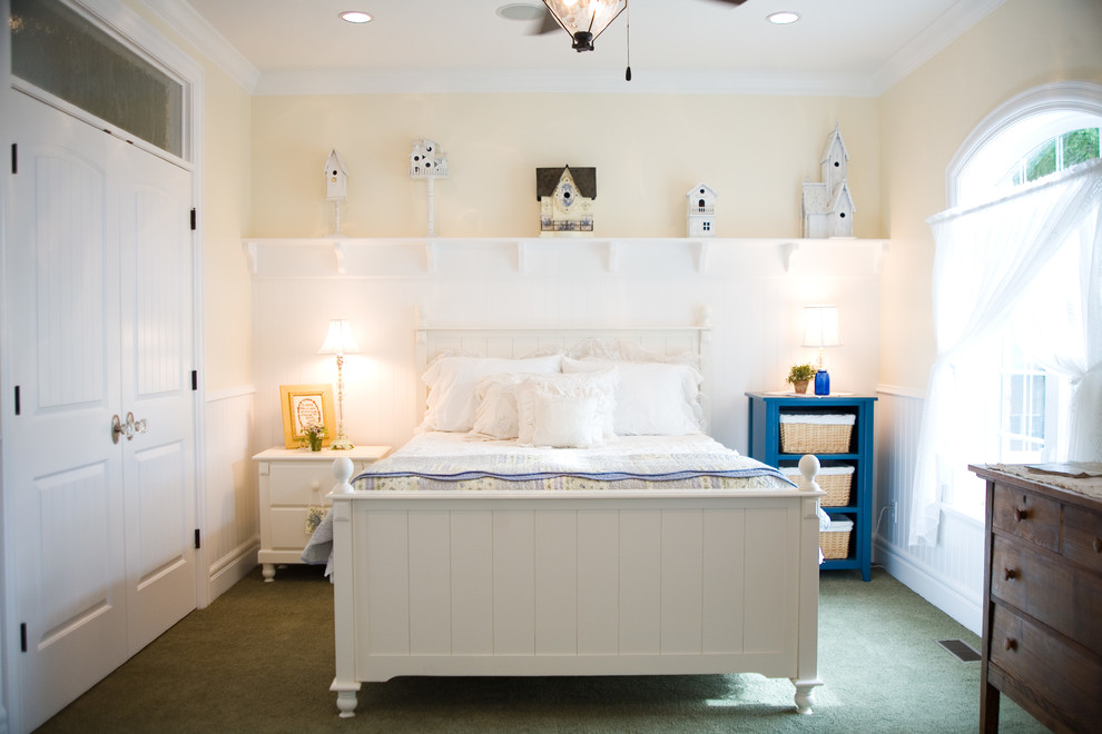 Imagen de habitación de invitados campestre de tamaño medio con paredes amarillas y moqueta
