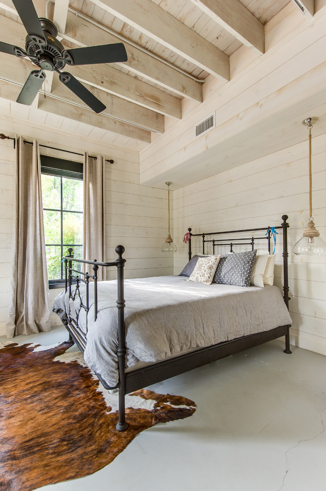 This is an example of a medium sized rural guest bedroom in Austin with white walls and medium hardwood flooring.