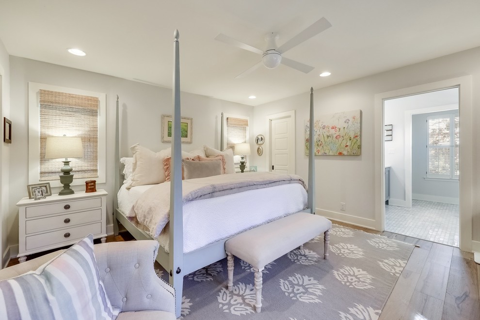 Landhausstil Hauptschlafzimmer mit weißer Wandfarbe, braunem Holzboden und braunem Boden in Austin