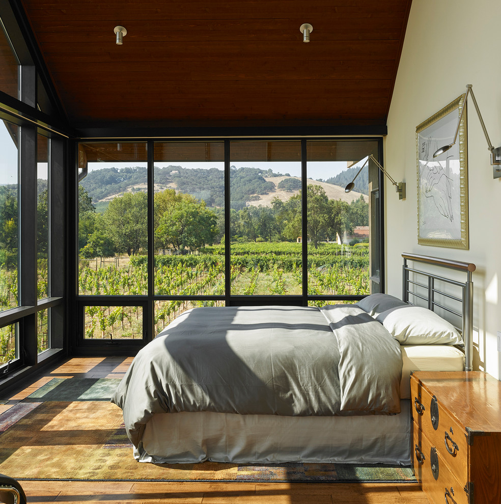 Foto de dormitorio de estilo de casa de campo con suelo de madera en tonos medios y suelo marrón