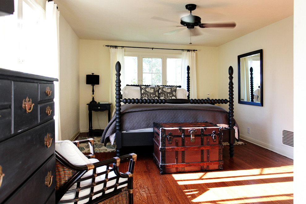 Foto på ett lantligt sovrum, med vita väggar och mellanmörkt trägolv