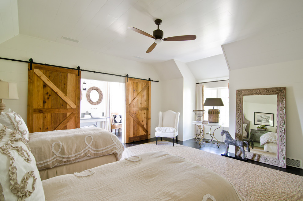 Cette image montre une chambre d'amis rustique avec un mur blanc et parquet foncé.