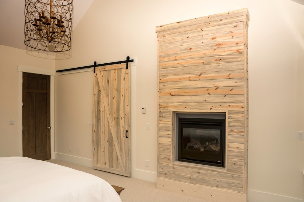 Mittelgroßes Country Hauptschlafzimmer mit beiger Wandfarbe, Teppichboden, Kamin und Kaminumrandung aus Holz in Sonstige