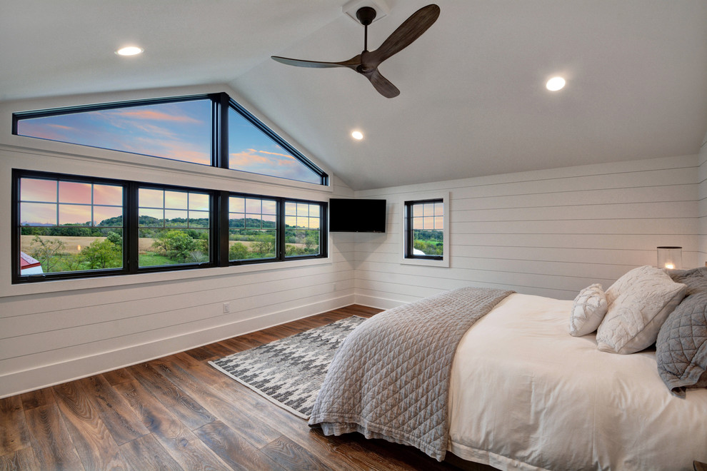 Esempio di una camera matrimoniale country con pareti bianche, pavimento in legno massello medio e pavimento marrone