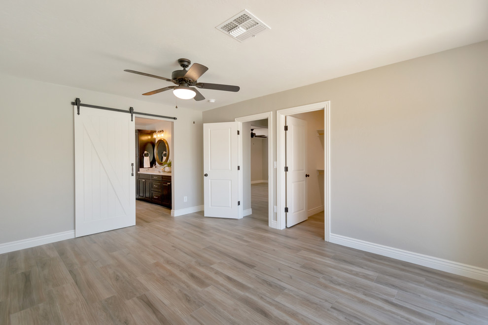 Example of a mid-sized country master porcelain tile and brown floor bedroom design in Phoenix with gray walls