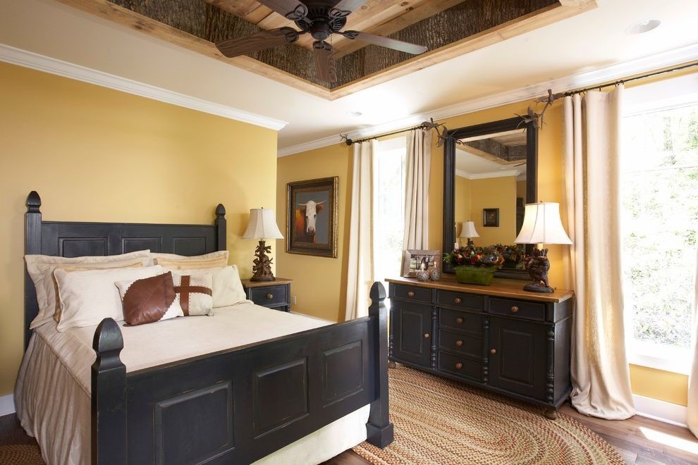 Ispirazione per una camera matrimoniale country di medie dimensioni con pareti gialle e pavimento in legno massello medio