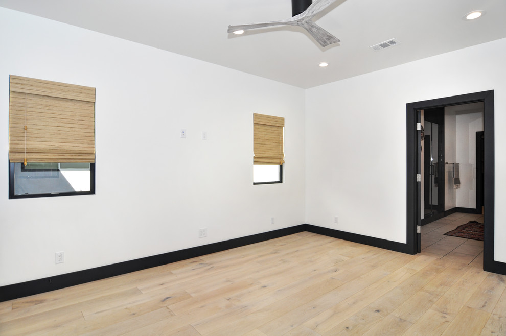 Großes Klassisches Gästezimmer ohne Kamin mit hellem Holzboden, beigem Boden und weißer Wandfarbe in Orange County