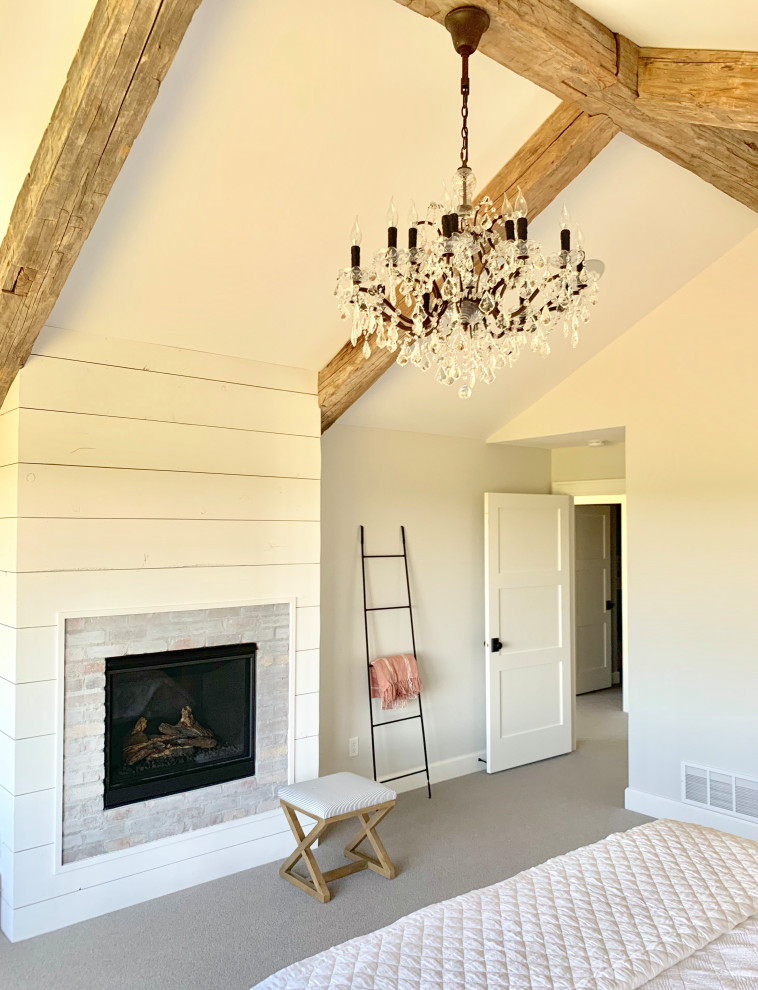 Inspiration for a large farmhouse master bedroom in Other with grey walls, carpet, a standard fireplace, a brick fireplace surround and grey floors.