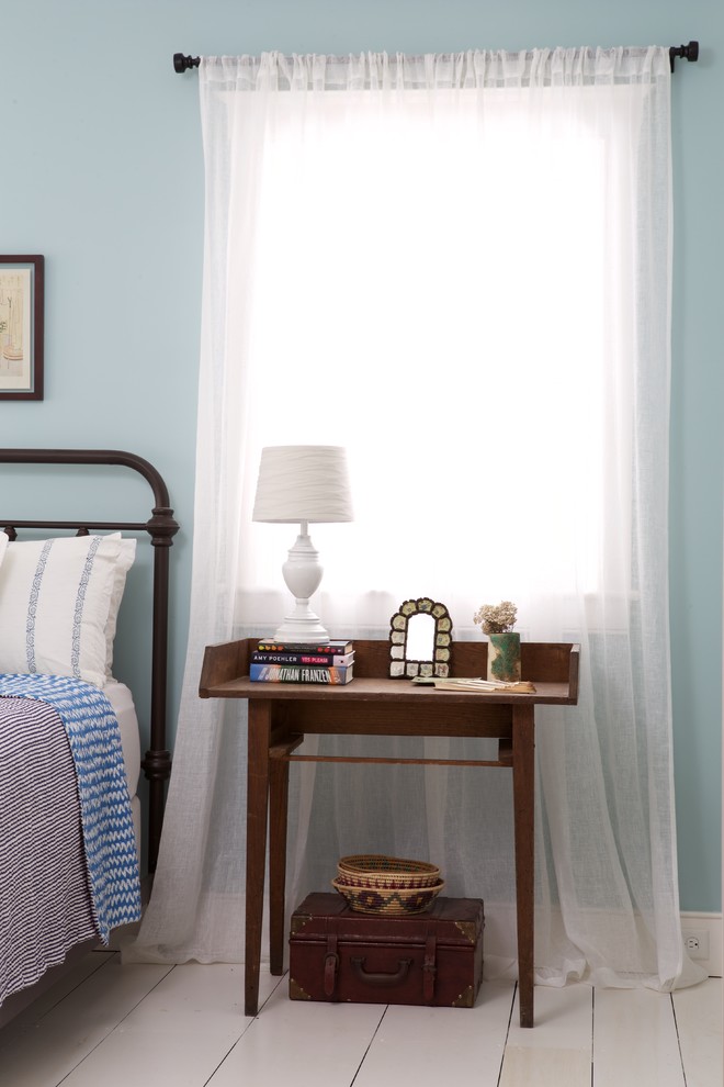 Modelo de dormitorio de estilo de casa de campo con paredes azules y suelo de madera pintada