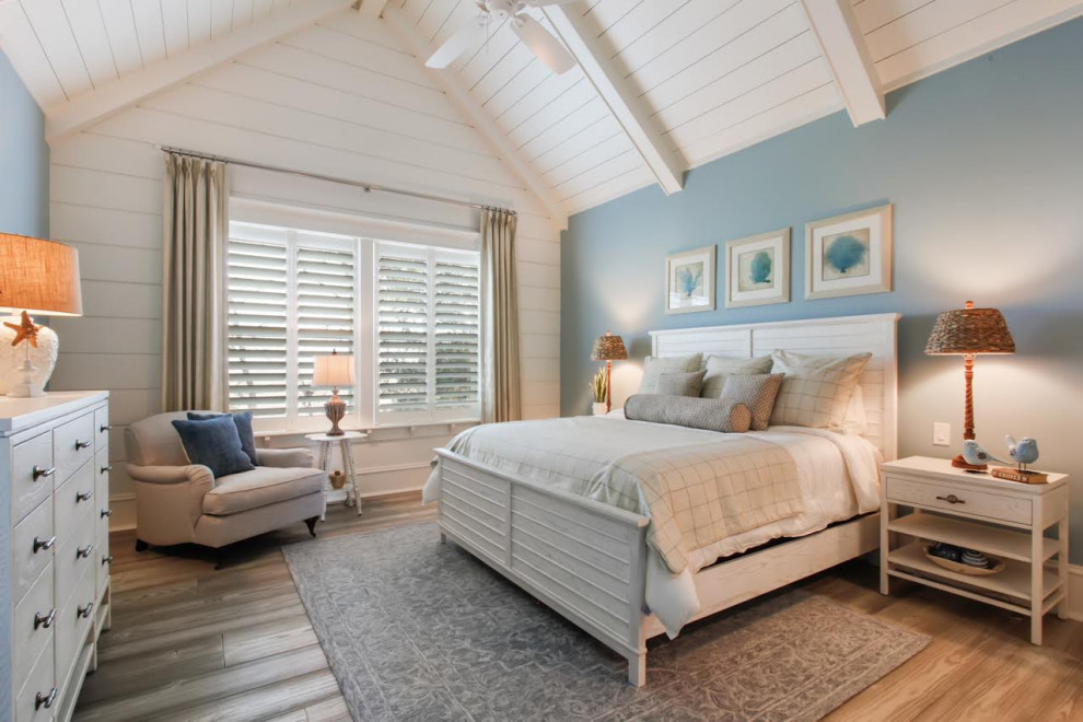 Diseño de habitación de invitados campestre sin chimenea con paredes azules, suelo de madera clara y suelo beige