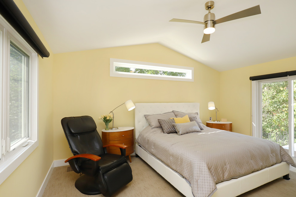 Modelo de dormitorio principal tradicional renovado de tamaño medio sin chimenea con paredes amarillas, moqueta y suelo beige