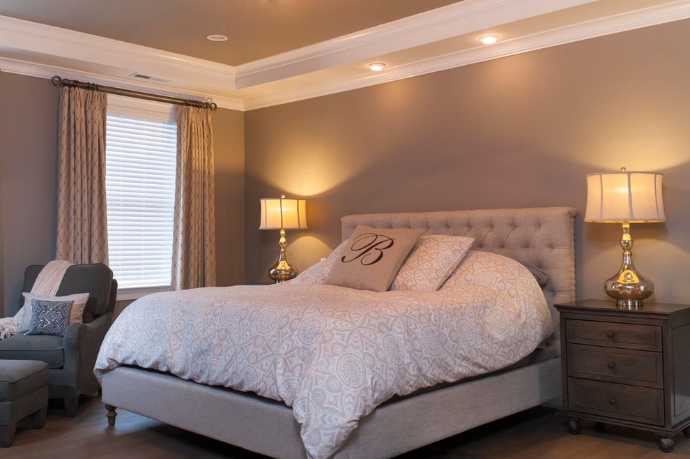 Example of a mid-sized transitional master medium tone wood floor bedroom design in New York with beige walls