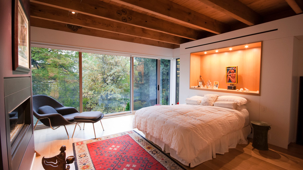 Свежая идея для дизайна: спальня в стиле неоклассика (современная классика) с белыми стенами, полом из ламината, горизонтальным камином и балками на потолке - отличное фото интерьера
