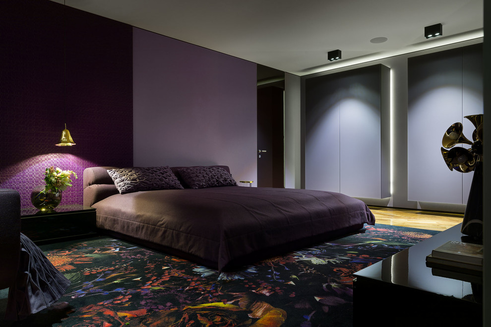 Идея дизайна: большая хозяйская спальня в стиле модернизм с фиолетовыми стенами, деревянным полом и коричневым полом