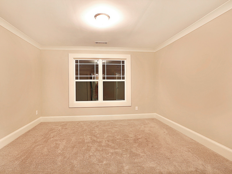 This is an example of a traditional bedroom in Atlanta with grey walls and carpet.