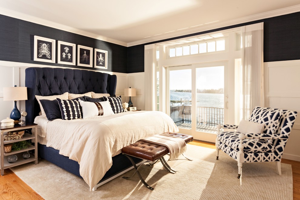Modelo de dormitorio principal costero de tamaño medio sin chimenea con suelo de madera en tonos medios y paredes azules