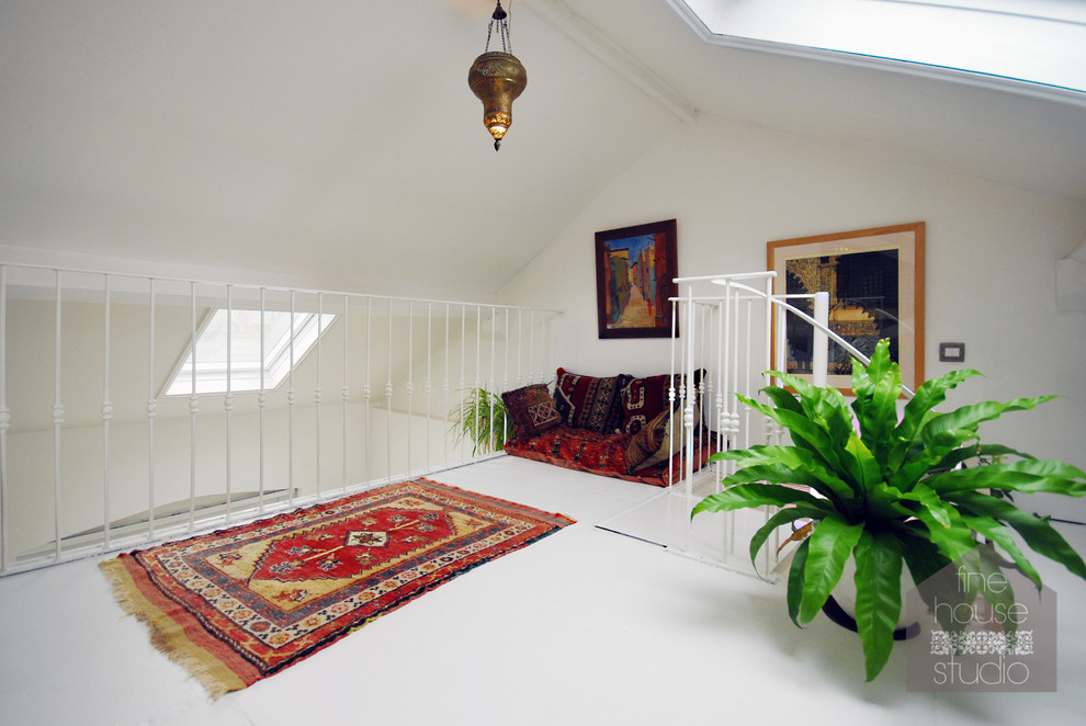 Foto de dormitorio tipo loft bohemio de tamaño medio con paredes blancas y techo inclinado