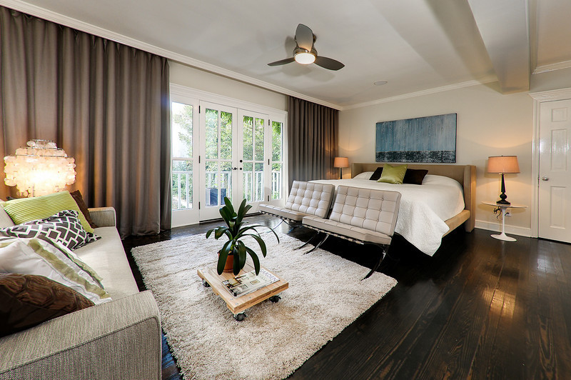 Modelo de dormitorio principal actual de tamaño medio sin chimenea con paredes beige y suelo de madera oscura