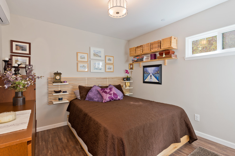 Modelo de dormitorio principal de estilo zen de tamaño medio sin chimenea con paredes grises, suelo de madera en tonos medios y suelo marrón