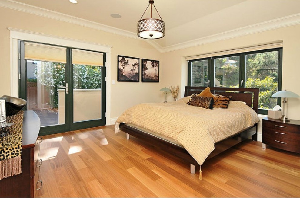 Aménagement d'une très grande chambre d'amis contemporaine avec un mur beige et un sol en bois brun.