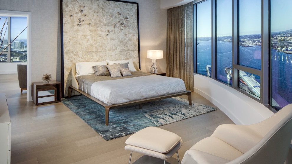 Example of a huge minimalist master light wood floor and beige floor bedroom design in San Diego with beige walls