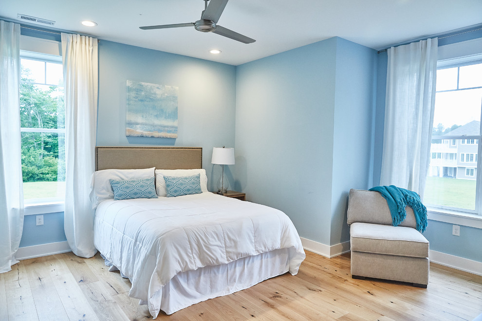 Maritimes Gästezimmer ohne Kamin mit blauer Wandfarbe, hellem Holzboden und beigem Boden in Sonstige