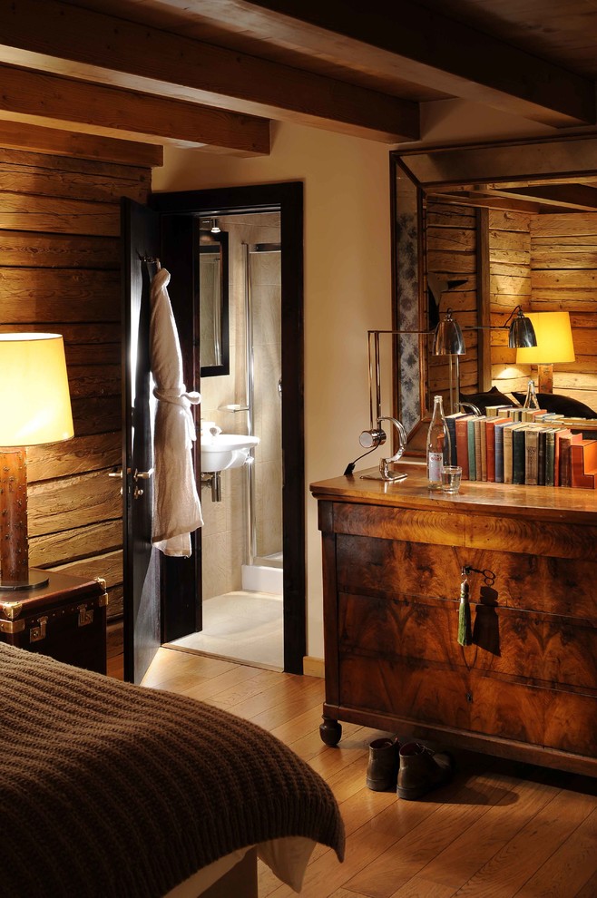 Ejemplo de dormitorio principal de estilo americano de tamaño medio sin chimenea con paredes amarillas, suelo de madera clara y suelo marrón