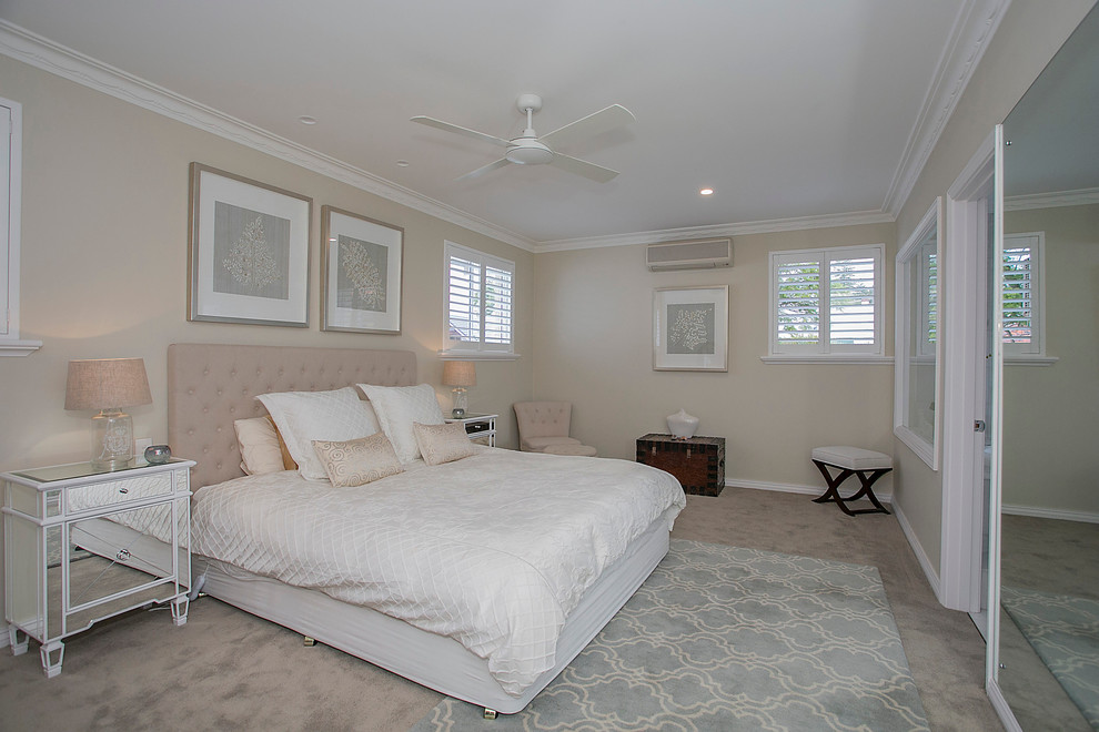 Medium sized beach style master bedroom in Perth with beige walls and carpet.
