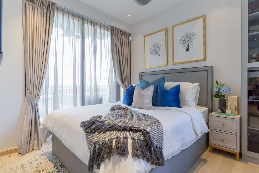 Immagine di una camera da letto design con pareti grigie, parquet chiaro e pavimento beige