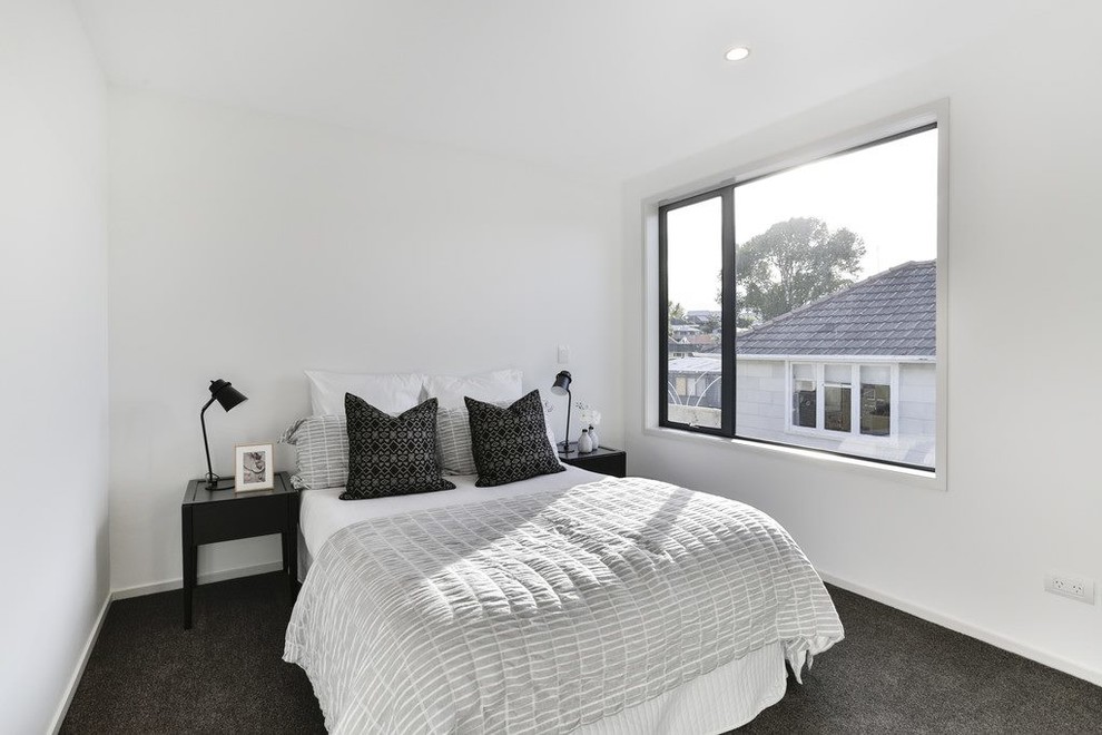 Cette image montre une chambre minimaliste de taille moyenne avec un mur blanc et un sol gris.