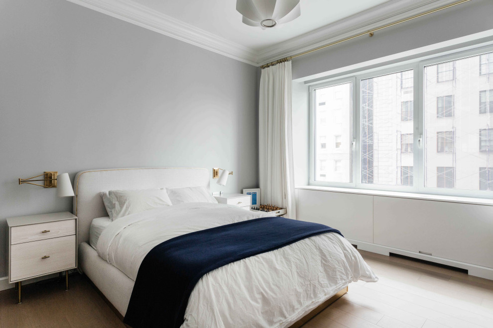 Example of a mid-sized trendy master light wood floor and beige floor bedroom design in New York with gray walls
