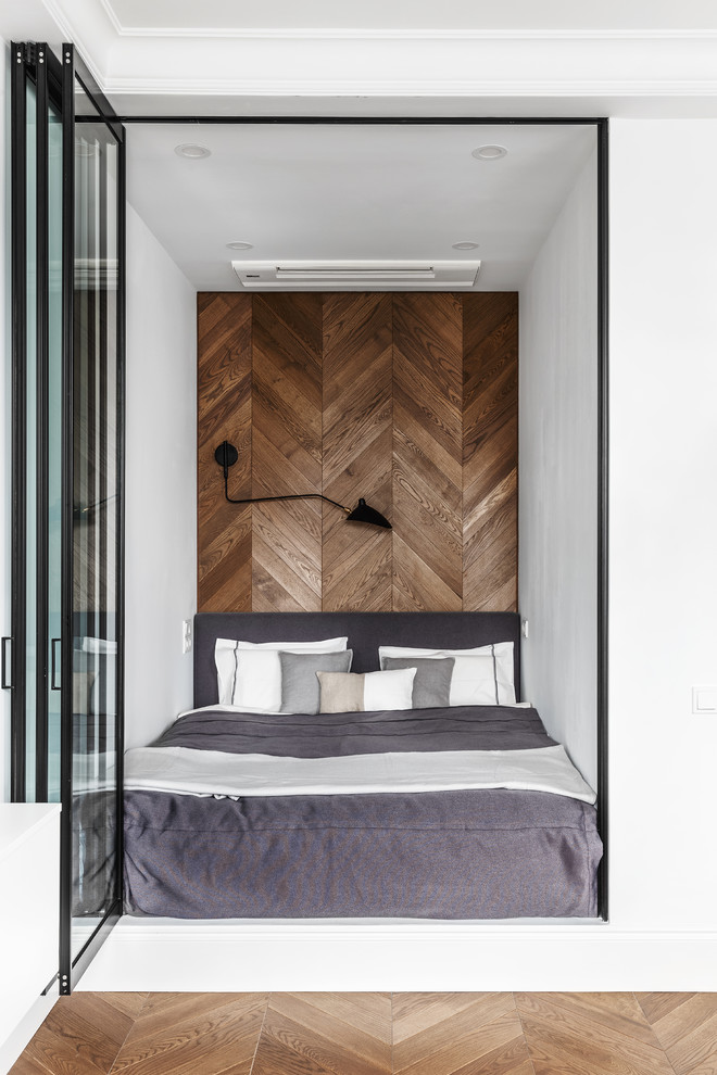 Ejemplo de dormitorio principal contemporáneo con suelo de madera en tonos medios, suelo marrón y paredes blancas